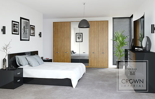 A large bedroom from Crown Imperials lifespace range featuring Crowns Furore black gloss furniture and Olive Light wood effect fronted wardrobe.