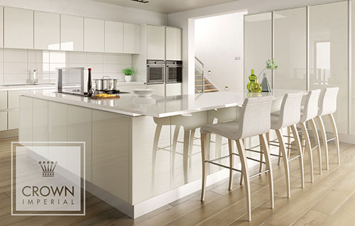 A modern white gloss kitchen from Crown Imperials Calypso range with a wooden floor.